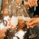 person pouring champagne on champagne flutes